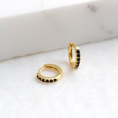 "An all-time bestseller. Elegant and classic, these tiny huggie hoops prong-set with black zirconia gemstones are a beautifully dainty addition to your everyday lineup. Subtle, versatile and perfect to mix and match with other earrings. * D E T A I L S * ∙ Sold individually (1 hoop) or by pair (2 hoops) ∙ Material: .925 Sterling Silver or 18K Gold Plated over .925 Sterling Silver ∙ Stone: Black Zirconia ∙ Dimensions: Hoop Diameter: 10mm // Width: 1.5mm ∙ Hypoallergenic & nickel-free * P A C K A Small Hoop Earrings Gold, Earrings Huggies, Earrings Gold Hoop, Dainty Hoop Earrings, Tiny Hoop Earrings, Small Hoop Earrings, Ear Cuffs, Huggie Hoop Earrings, Everyday Earrings