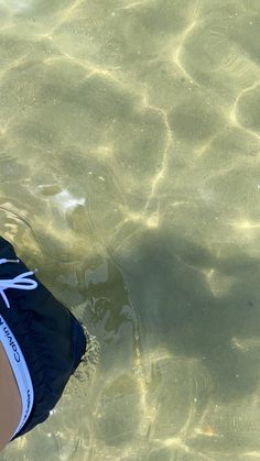 a person standing in the water with their feet up