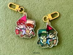 two keychains with cartoon characters on them sitting on the floor next to each other