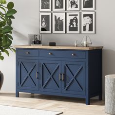 a blue sideboard with pictures on the wall behind it