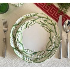 a white plate topped with peas next to silverware