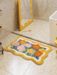 a yellow rug with flowers on it next to a sink