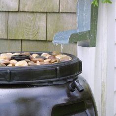 a large black pot filled with donuts on top of a wooden table next to a house