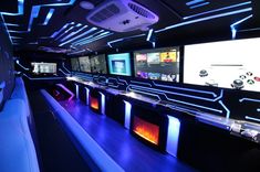 the interior of a bowling alley with neon lights and video screens on the wall behind it