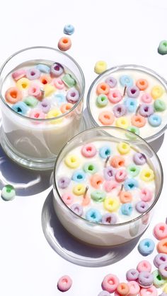 three bowls filled with cereal sitting on top of a white table next to candy beans