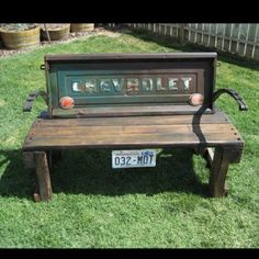 an old bench with the word charlotte on it is in front of a fence and grass