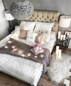 a bed with white pillows and lights on it