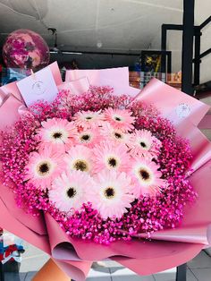 a bouquet of pink flowers is wrapped in pink paper