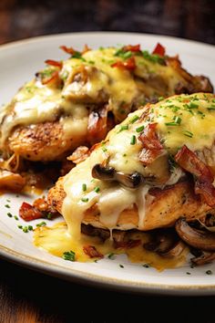 a white plate topped with chicken covered in cheese and mushrooms on top of a wooden table