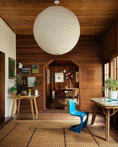 a room with wood paneling and a blue chair in the middle of the room