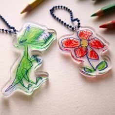 two plastic keychains with colored drawings on them and one has a flower in the middle