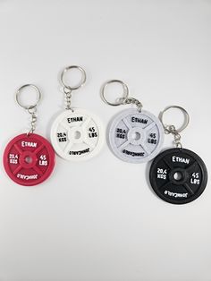 three key chains with different types of weight plates on each one and the other side