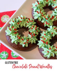 three chocolate donuts decorated with green and red sprinkles on a white plate