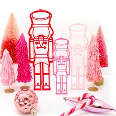 pink and red paper cut out of christmas trees with candy canes next to them