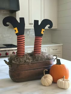 two halloween legs sitting on top of a pot filled with hay