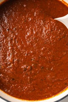 a white bowl filled with red sauce on top of a table