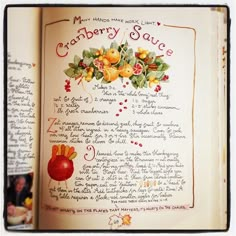 an open book with drawings and writing on the inside pages, including oranges and apples