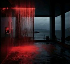 a shower head with red water running down it's side in front of a window