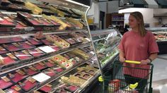 a woman standing in front of a grocery cart