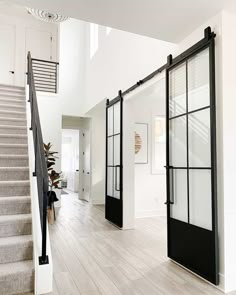 an open living room with stairs and glass doors