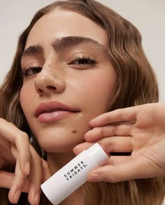 a woman holding a tube of sunscreen in her hand