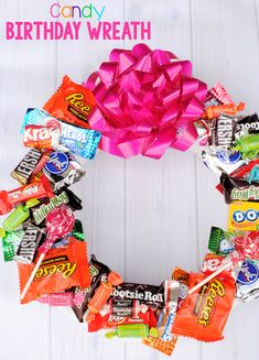 a wreath made out of candy bars on a white wooden background with the words candy birthday wreath