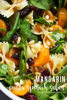 pasta salad with oranges and spinach in a white bowl