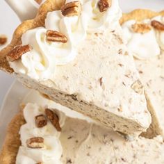 a piece of pie with whipped cream and pecans on top