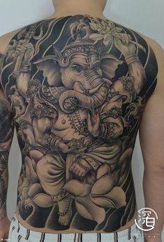 the back of a man's body with an elephant tattoo design on his chest