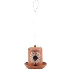 a bird feeder with a flower design on the top and a wire attached to it