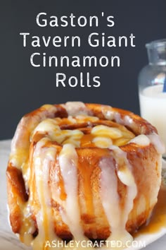 a close up of a cinnamon roll on a plate with a glass of milk in the background