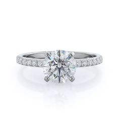 a round brilliant cut diamond ring with pave set shoulders