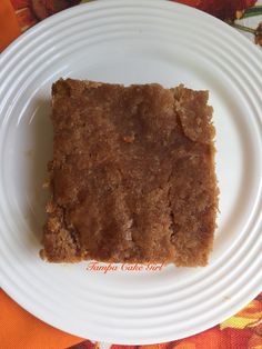 a piece of cake sitting on top of a white plate next to an orange napkin