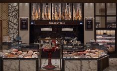 an assortment of meats and pastries displayed in a display case at a store