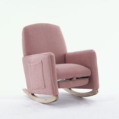 a pink rocking chair sitting on top of a white floor next to a wooden frame