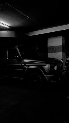 a black and white photo of a car parked in a parking garage next to another vehicle