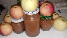 there are many apples and peanut butter in the jars on the counter top, including an apple