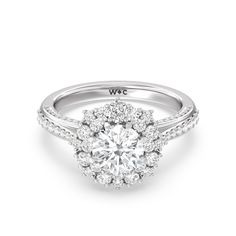 a white gold engagement ring with round diamonds on the band and an oval center stone