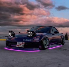 a purple car with two lights on it's hood