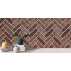 two vases with plants on top of books in front of a brick pattern wall