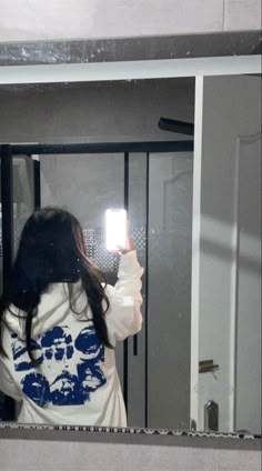 a woman taking a selfie in front of a mirror