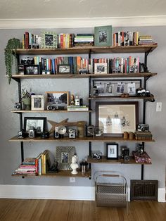 a bookshelf filled with lots of books on top of wooden shelves next to a wall