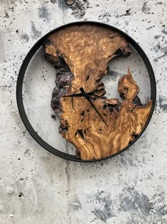 a clock made out of wood with the shape of a world map on it's face