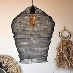 there is a woven piece hanging from the ceiling next to other items on the wall