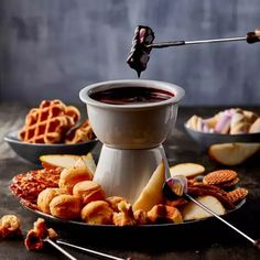 a plate filled with waffles, apples and other food on top of a table