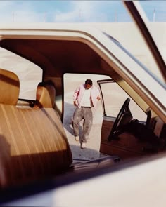 a man is walking into the back seat of a car