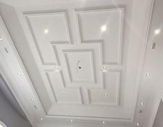 the ceiling in this room is decorated with square and rectangle shapes, along with recessed lighting