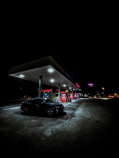 a car parked in front of a gas station at night