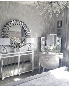 a bedroom with mirrored furniture and chandelier in the corner, along with a large mirror on the wall