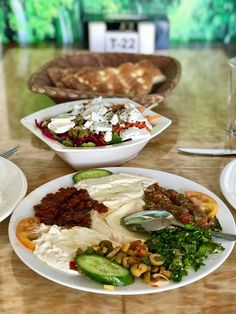 a table topped with plates and bowls filled with different types of food on top of it